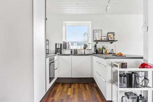 a white kitchen with white cabinets and a window at LF13170-Nykobing-mors-Havevej-22 in Nykøbing Mors