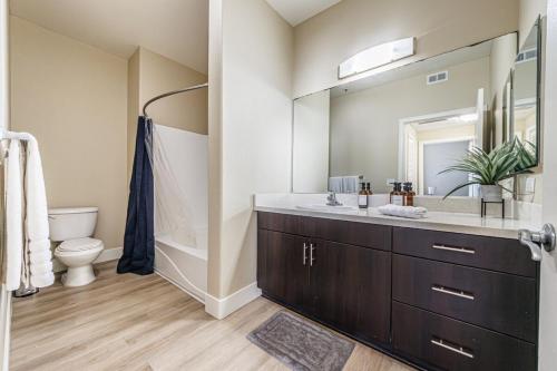 Un baño con lavabo, inodoro y espejo. en 2BD Marina Condo Near Venice Beach, Pool & Free Parking, en Los Ángeles