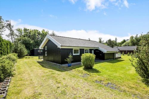a small house with a black exterior and a yard at LF16182-Logstor-Minnasvej-50 in Løgstør