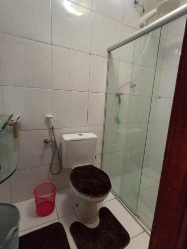 a bathroom with a toilet and a glass shower at Casa Pajuçara in Maceió