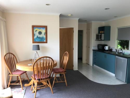 une cuisine et une salle à manger avec une table et des chaises dans l'établissement The Cottage on Hurford - New Plymouth, à New Plymouth