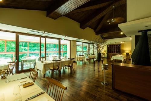 a dining room with tables and chairs and windows at Myojinkan in Matsumoto