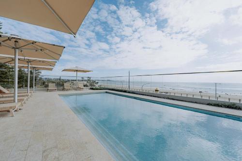 a swimming pool with a view of the beach at Solara at Kirra - 2 Bedroom Sub-Penthouse in Gold Coast