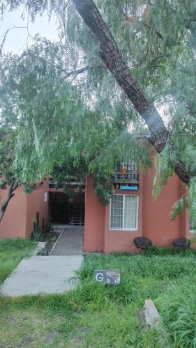 a red house with a tree in front of it at Depa boho in Laborcillas