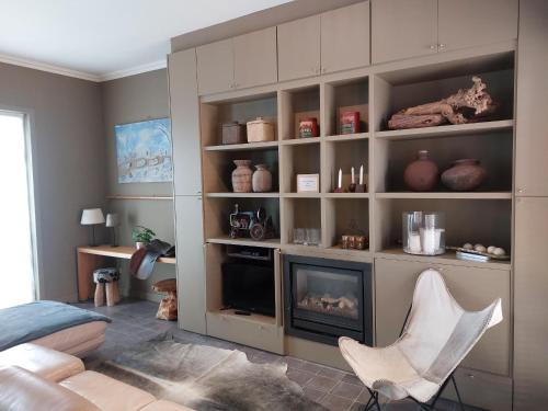 a living room with a fireplace and a chair at Huis aan Puyenbroeck in Wachtebeke