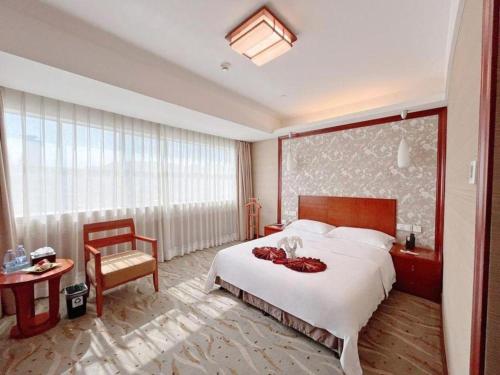 a hotel room with a bed and a large window at Xiamen Jingmin Central Hotel in Xiamen