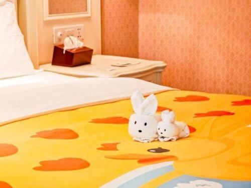 two rabbits sitting on a bed in a room at Xiamen Jingmin Central Hotel in Xiamen