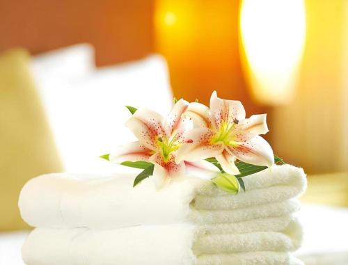 a bouquet of white flowers sitting on top of towels at Xiamen Jingmin Central Hotel in Xiamen