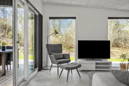 a living room with a television and a chair at LF302-Hurup-Helligsovej-2-F in Hurup