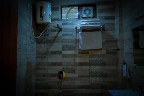 a bathroom with a shower with towels and a window at Hotel Jaisal Inn - Pure Veg in Jaisalmer