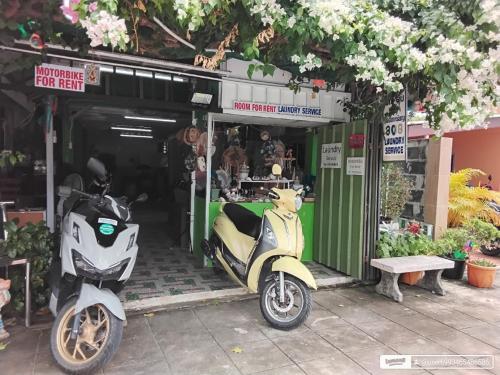 a motor scooter parked in front of a store at Green Salad Hostel in Ban Thong Phlu