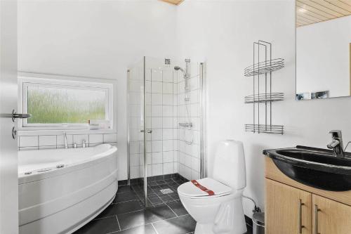 a bathroom with a tub sink and a toilet at LF530-Vestervig-Hannesvej-30 in Vestervig