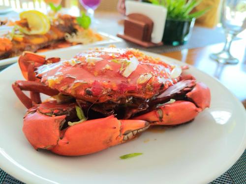 a lobster on a white plate on a table at Asia Grand View Hotel in Coron