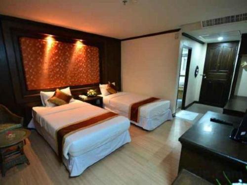 a hotel room with two beds and a television at Piyaporn Pavilion Hotel in Mae Sai