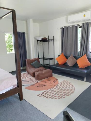 a living room with a bed and a couch at Green Salad Hostel in Ban Bang Po