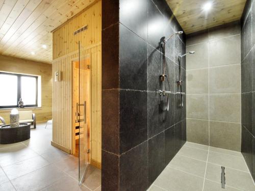 a bathroom with a shower with a glass door at Walk Luxury Stay with Pool in Robertville