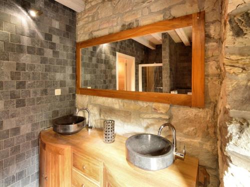 a stone bathroom with two sinks and a mirror at Walk Luxury Stay with Pool in Robertville