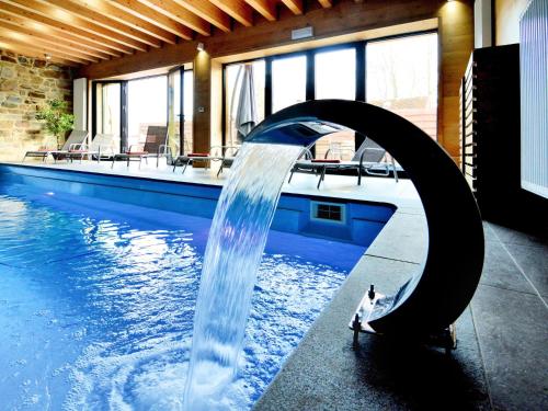 a person standing in a pool with a water fountain at Walk Luxury Stay with Pool in Robertville