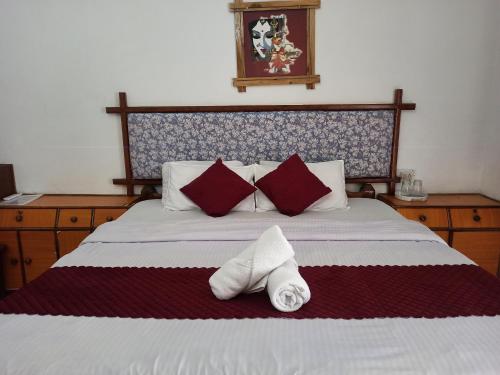 a bedroom with a bed with red and white pillows at Zappia Cove Resort Palolem in Palolem