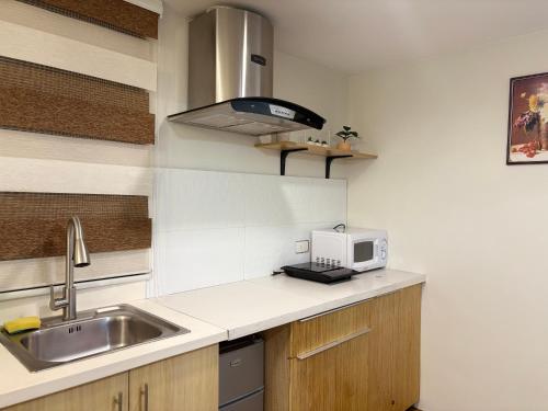 a kitchen with a sink and a microwave at Studio Unit at Pine Suites Tagaytay in Tagaytay