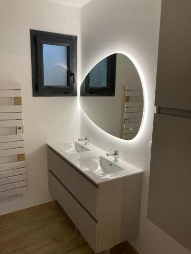 a bathroom with a sink and a mirror at Charmante maison près de la gare 2 chambres in Jonzac