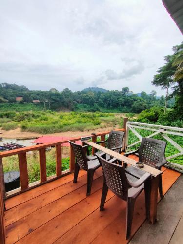 a wooden deck with chairs and a table on it at Wild Lodge Taman Negara in Kuala Tahan