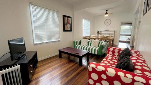 a living room with two couches and a table at Teke Cottage in Wooli