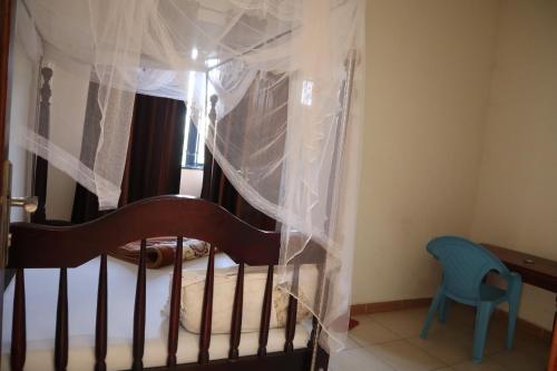 a bedroom with a crib with mosquito nets at Namulanda Motel in Entebbe