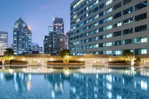 a building with a large pool of water in front of a city at Yuexiu Hotel Guangzhou,Curio Collection by Hilton-Free shuttle between hotel and Exhibition Center during Canton Fair & Exhibitor Registration Counter in Guangzhou