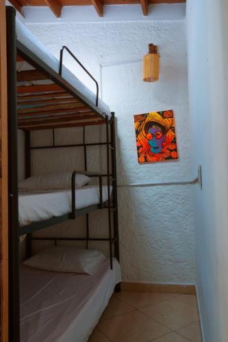 a room with two bunk beds and a painting on the wall at Jungle House Medellin in Medellín