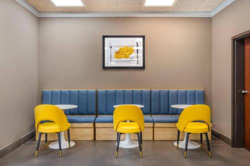 a waiting room with yellow chairs and a blue bench at Comfort Inn Pinehurst - Southern Pines in Pinehurst