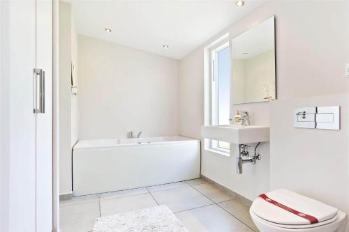 a white bathroom with a toilet and a sink at LF299-Vestervig-Ingersvej-21 in Vestervig