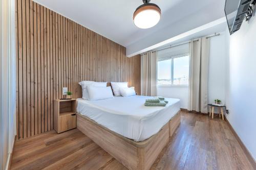 a bedroom with a large bed with a wooden wall at Apartamento Playa y Sol in Calpe