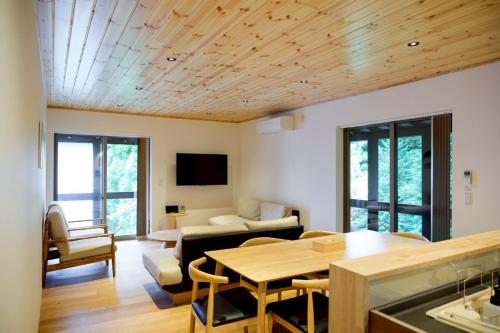a living room with a table and a couch at GRACE VILLA Aso Kurokawa in Minamioguni