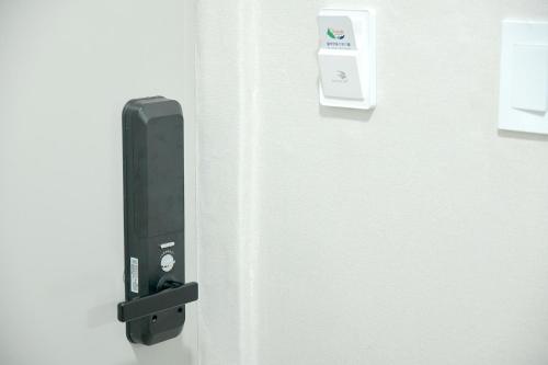 a black door with a lock on a white door at Sorak Hostel in Sokcho