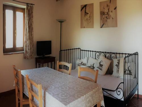 a room with a table and a bed and a couch at Tuscan Charm Near Volterra in Volterra
