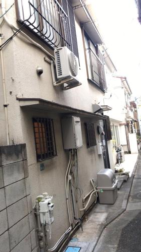 a building with an air conditioner on the side of it at Sweet House Sugamo 101 in Tokyo