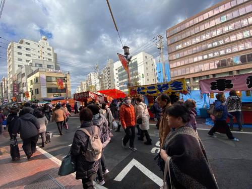 a crowd of people walking around a street market at Sweet House Sugamo 101 in Tokyo