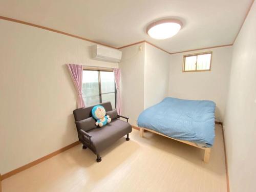 a small bedroom with a bed and a chair at Sweet House Sugamo 101 in Tokyo