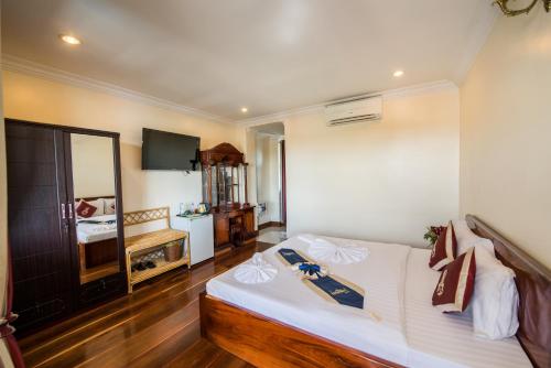 a living room with a bed and a television at Seng Hout Hotel in Battambang