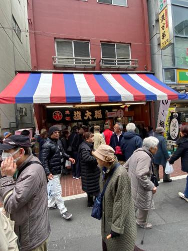 a group of people standing in front of a market at Sweet House Sugamo 101 in Tokyo