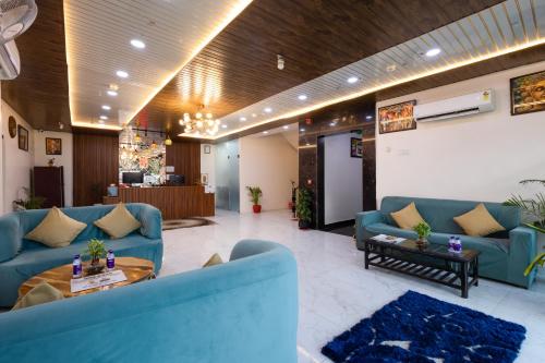 - un hall avec des canapés bleus et une table dans l'établissement Sarla Hotel Inn - Opp Barclays 62, à Noida