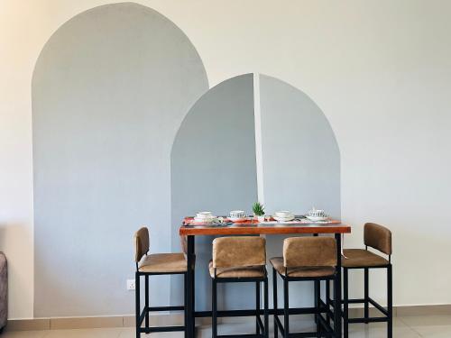 a dining room table with chairs in front of two arches at 马六甲 Melaka Amber cove residence Jonker Street in Melaka