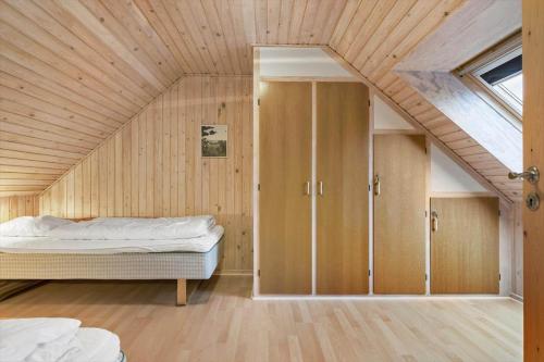 a bedroom with a bed in a room with an attic at 5577-Gudhjem-Norrelokke-18 in Gudhjem