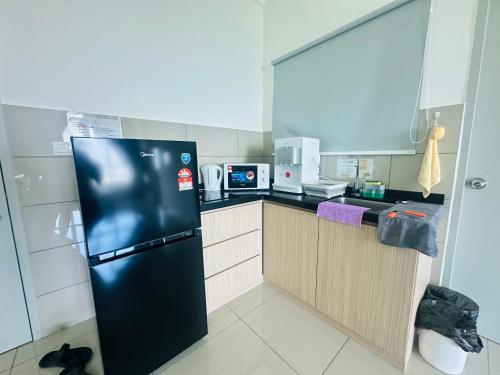 a small kitchen with a black refrigerator in it at 马六甲 Melaka Amber cove residence Jonker Street in Melaka