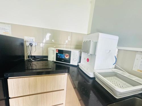 a kitchen with a black counter top with a microwave at 马六甲 Melaka Amber cove residence Jonker Street in Melaka