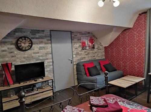 a living room with a couch and a tv at La cité des abeilles in Villemandeur