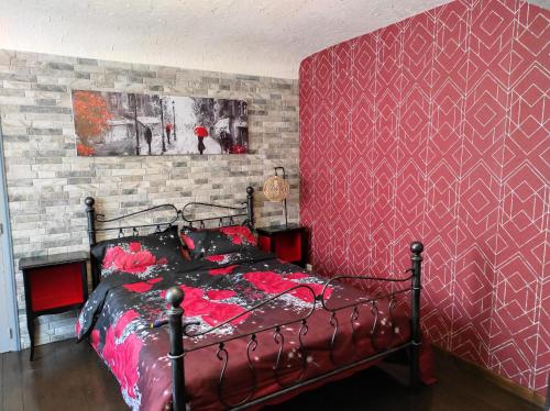 a bedroom with a bed with a red wall at La cité des abeilles in Villemandeur