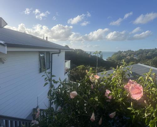 a view of a house with flowers in the yard at Deluxe Bedroom ldouble or twin bedl in shared Premium Villa at Waiheke Island Resort in Waiheke Island