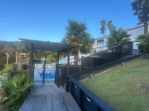 a wooden walkway leading to a swimming pool with a gate at Deluxe Bedroom ldouble or twin bedl in shared Premium Villa at Waiheke Island Resort in Waiheke Island